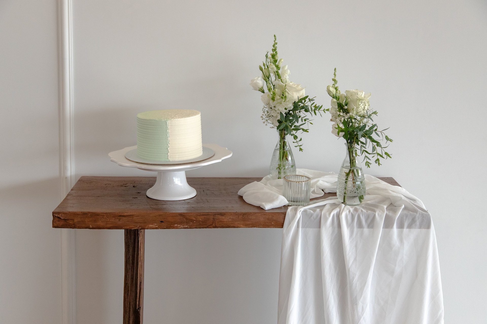 Pastel decorado artesanalmente con flores frescas en mesa de madera rústica